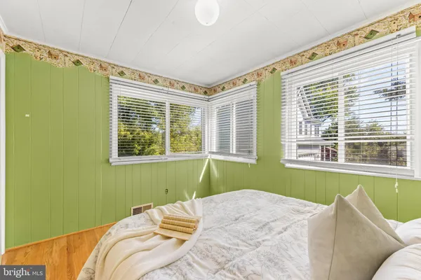 a bedroom with a bed and windows