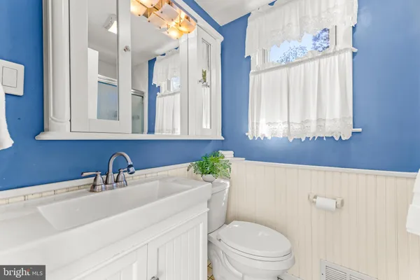 a bathroom with a sink a toilet and a mirror