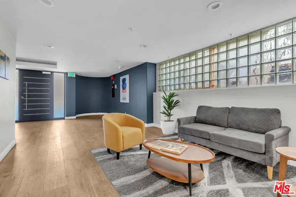 a view of an empty room with wooden floor and closet
