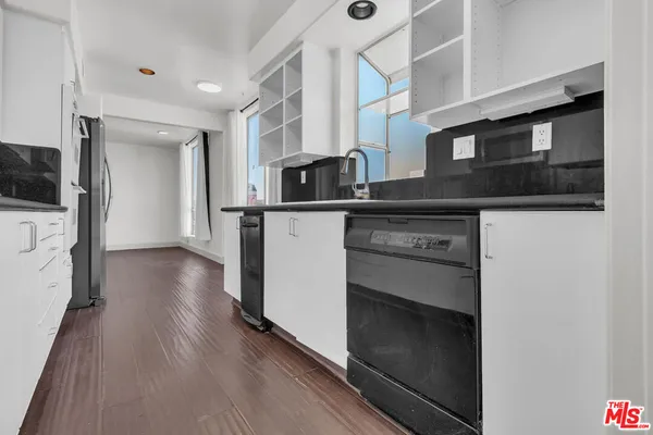 a kitchen with granite countertop a sink stove and microwave