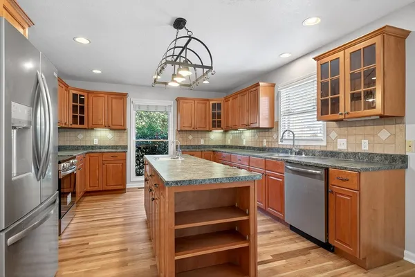 a kitchen with granite countertop stainless steel appliances and wooden cabinets