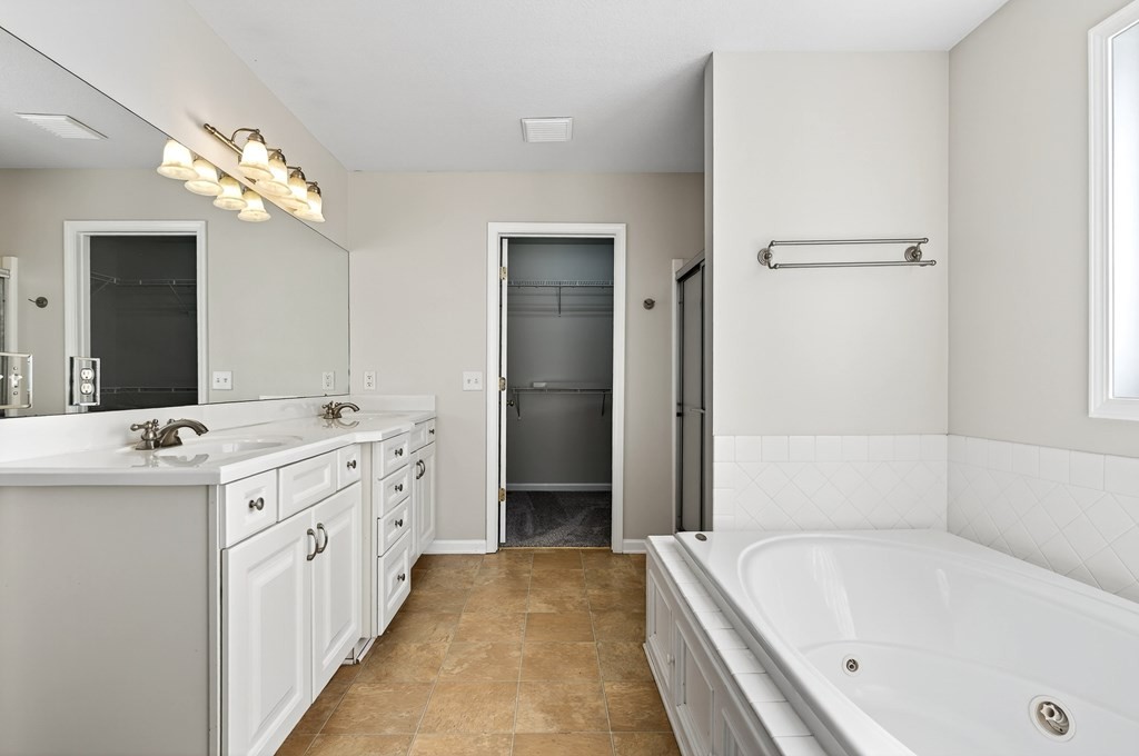 1325 Bridle Path Cookeville, TN 38501 - Photo 19 of 41 a bathroom with a tub a double vanity sink and a large mirror