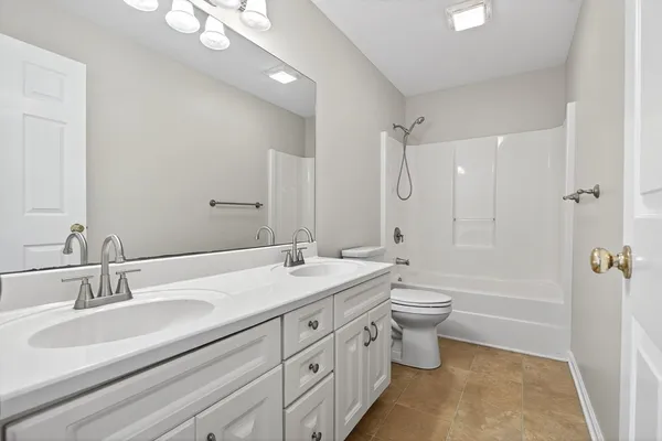 a bathroom with a double vanity sink toilet mirror and bathtub