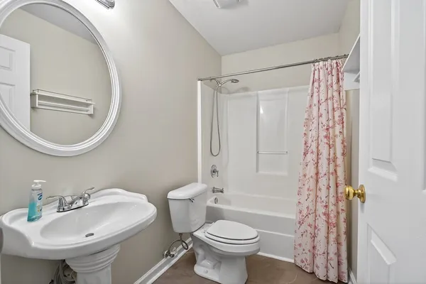 a bathroom with a sink toilet a mirror and shower