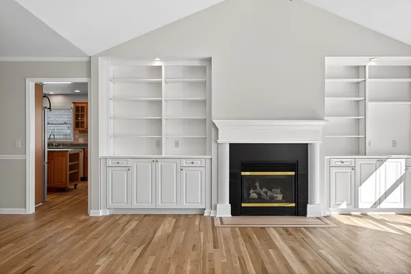 a view of an empty room with a fireplace and a window