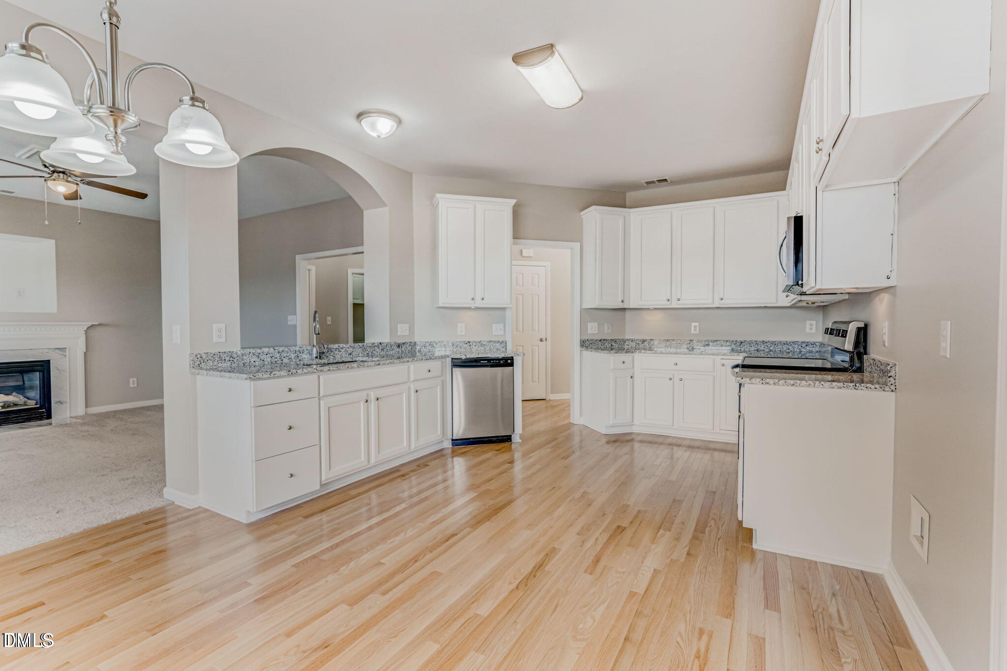 480 Seastone Street Raleigh, NC 27603 - Photo 11 of 26 a kitchen with wooden floors and white cabinets
