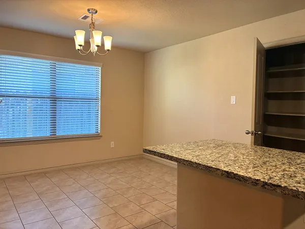 an empty room with a ceiling fan and window