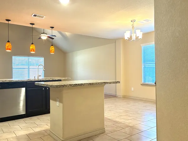 a kitchen with stainless steel appliances granite countertop a stove a sink and a microwave