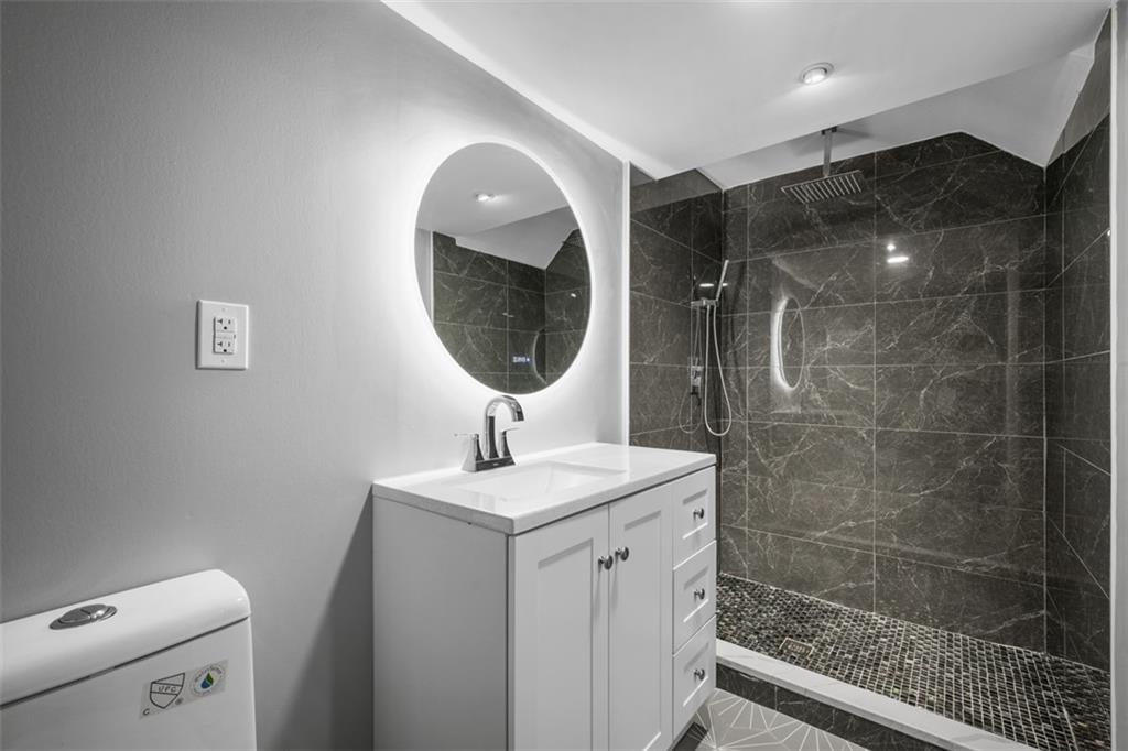 3943 Howley Street Pittsburgh, PA 15224 - Photo 23 of 32 a bathroom with a sink a toilet and a mirror