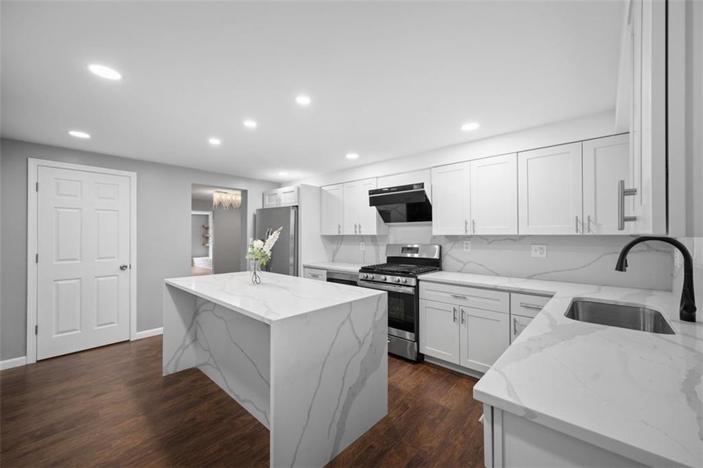 3943 Howley Street Pittsburgh, PA 15224 - Photo 7 of 32 a kitchen with stainless steel appliances a sink a stove a refrigerator cabinets and wooden floor