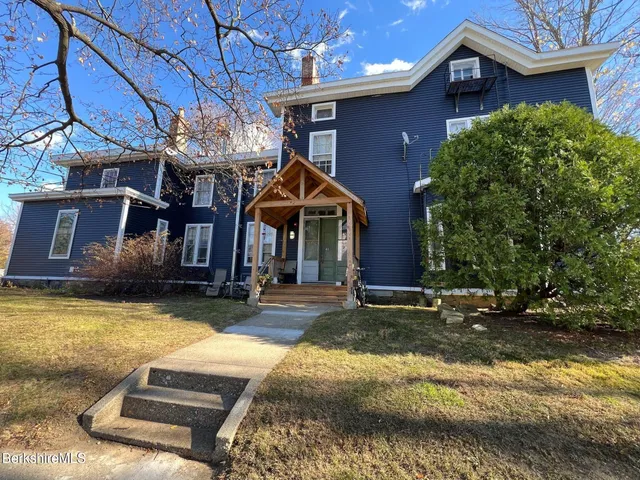a view of a house with a patio and a yard