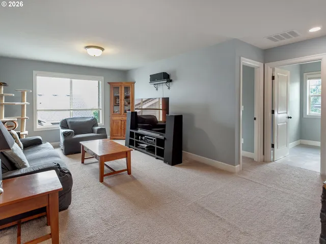 a living room with furniture a piano and a bookshelf