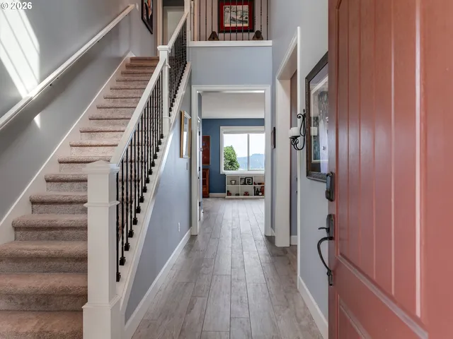 a view of a hallway with wooden floor and entryway