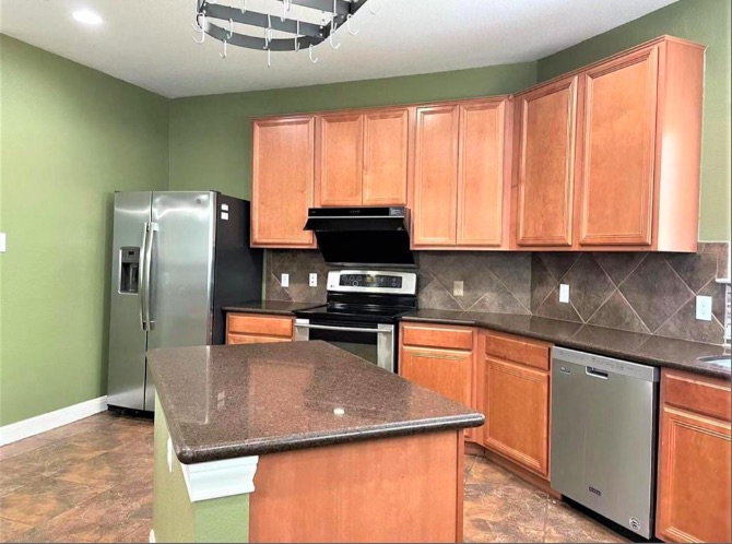 508 Tyree Road Cedar Park, TX 78613 - Photo 9 of 22 a kitchen with stainless steel appliances granite countertop a sink a stove a refrigerator a microwave a dining table and chairs with wooden floor