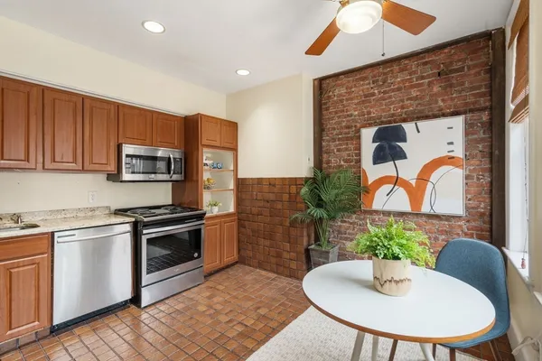 a kitchen with stainless steel appliances granite countertop a stove top oven a sink and a microwave
