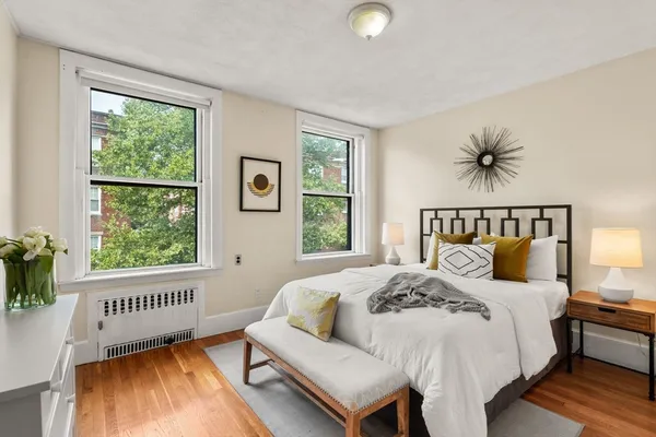 a bed sitting in a bedroom next to a window