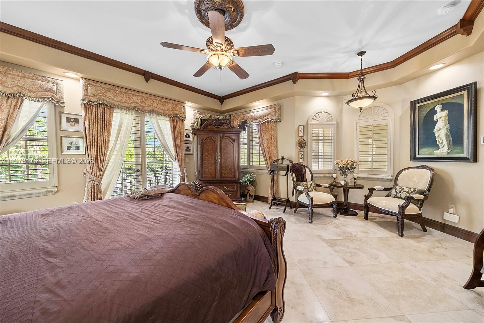 4501 North Bay Road Miami Beach, FL 33140 - Photo 10 of 24 a spacious bedroom with a bed a chandelier and a large window