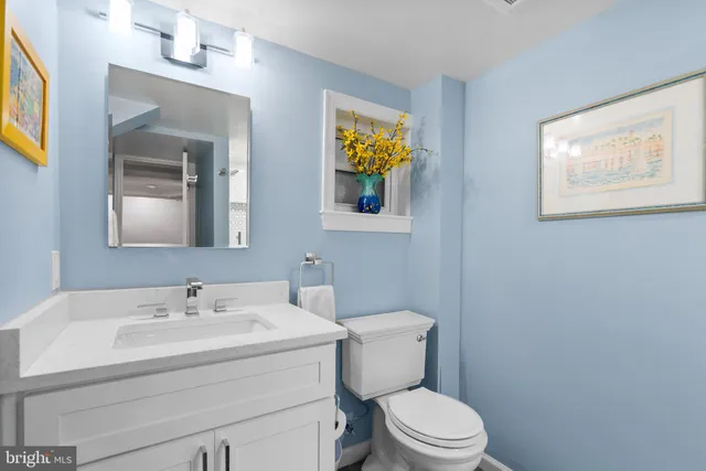 a bathroom with a toilet a sink and mirror