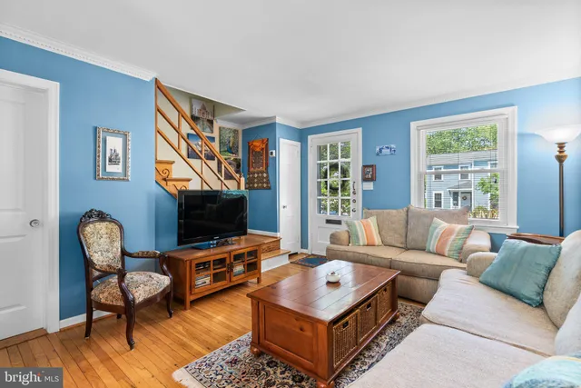 a living room with furniture a flat screen tv and a window