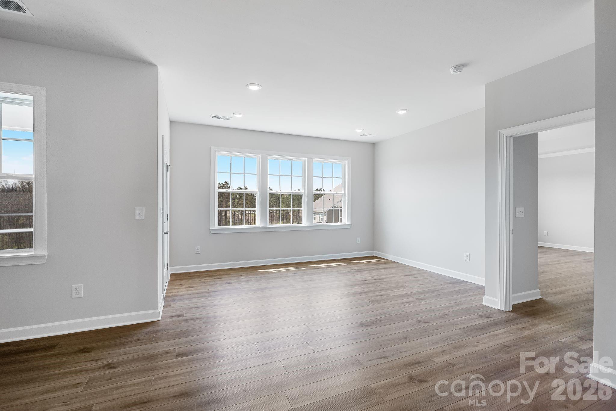 2287 Moon Crst Road, Unit 143 Lancaster, SC 29720 - Photo 12 of 35 an empty room with wooden floor and windows
