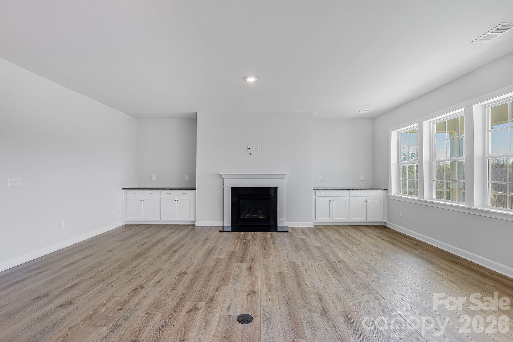 2287 Moon Crst Road, Unit 143 Lancaster, SC 29720 - Photo 15 of 35 wooden floor fireplace and windows in an empty room
