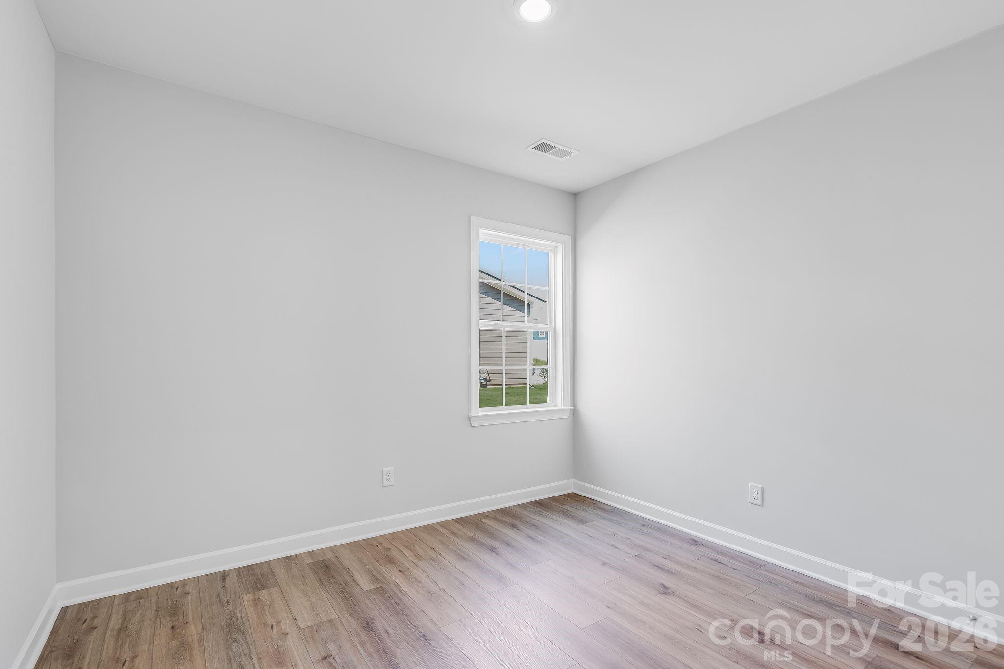 2287 Moon Crst Road, Unit 143 Lancaster, SC 29720 - Photo 16 of 35 a view of an empty room with wooden floor and a window