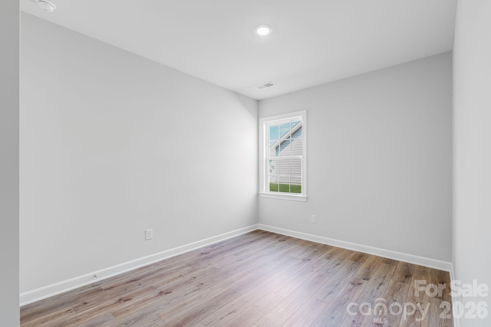 2287 Moon Crst Road, Unit 143 Lancaster, SC 29720 - Photo 17 of 35 an empty room with wooden floor and windows