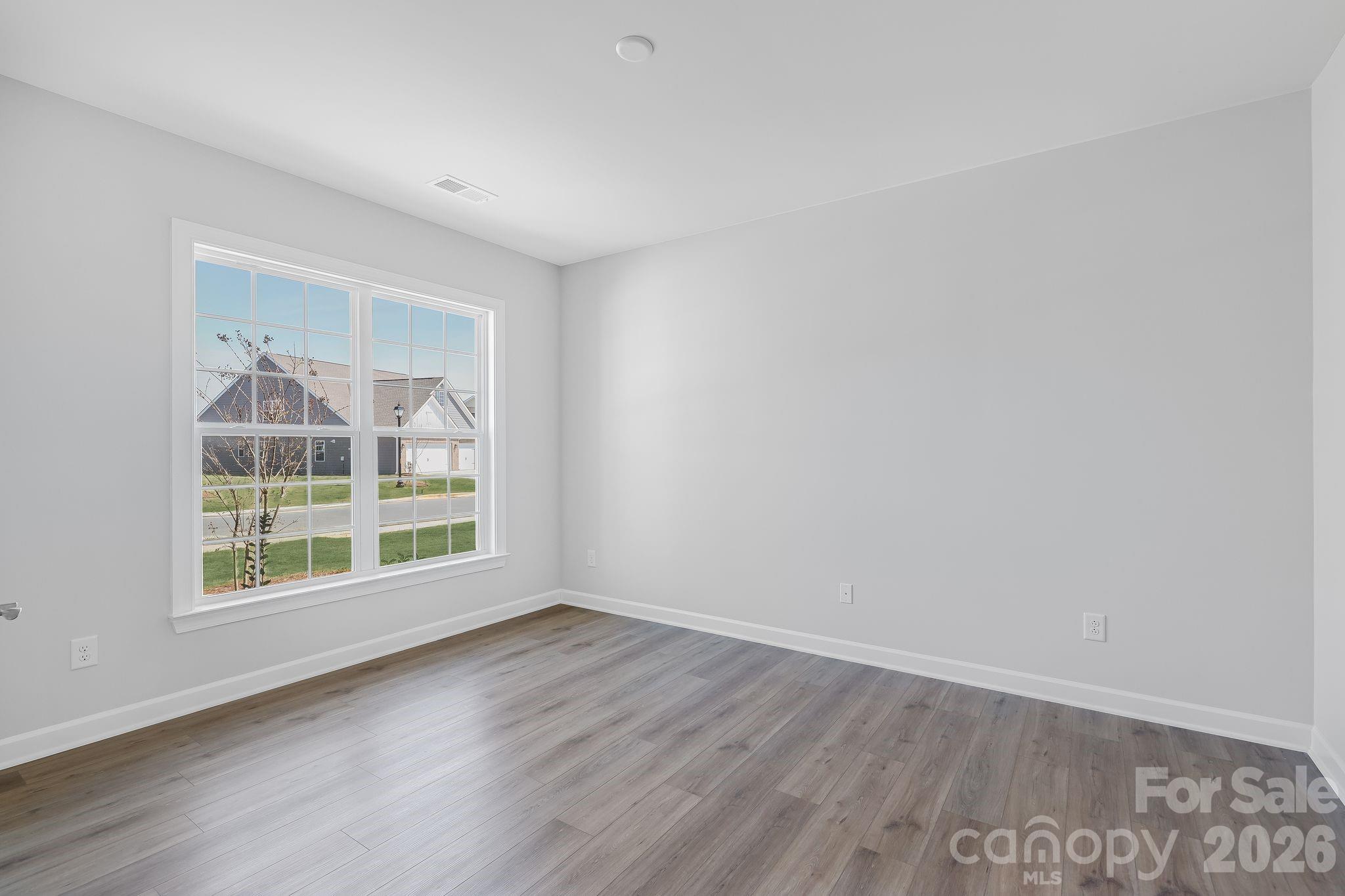 2287 Moon Crst Road, Unit 143 Lancaster, SC 29720 - Photo 18 of 35 an empty room with wooden floor and windows
