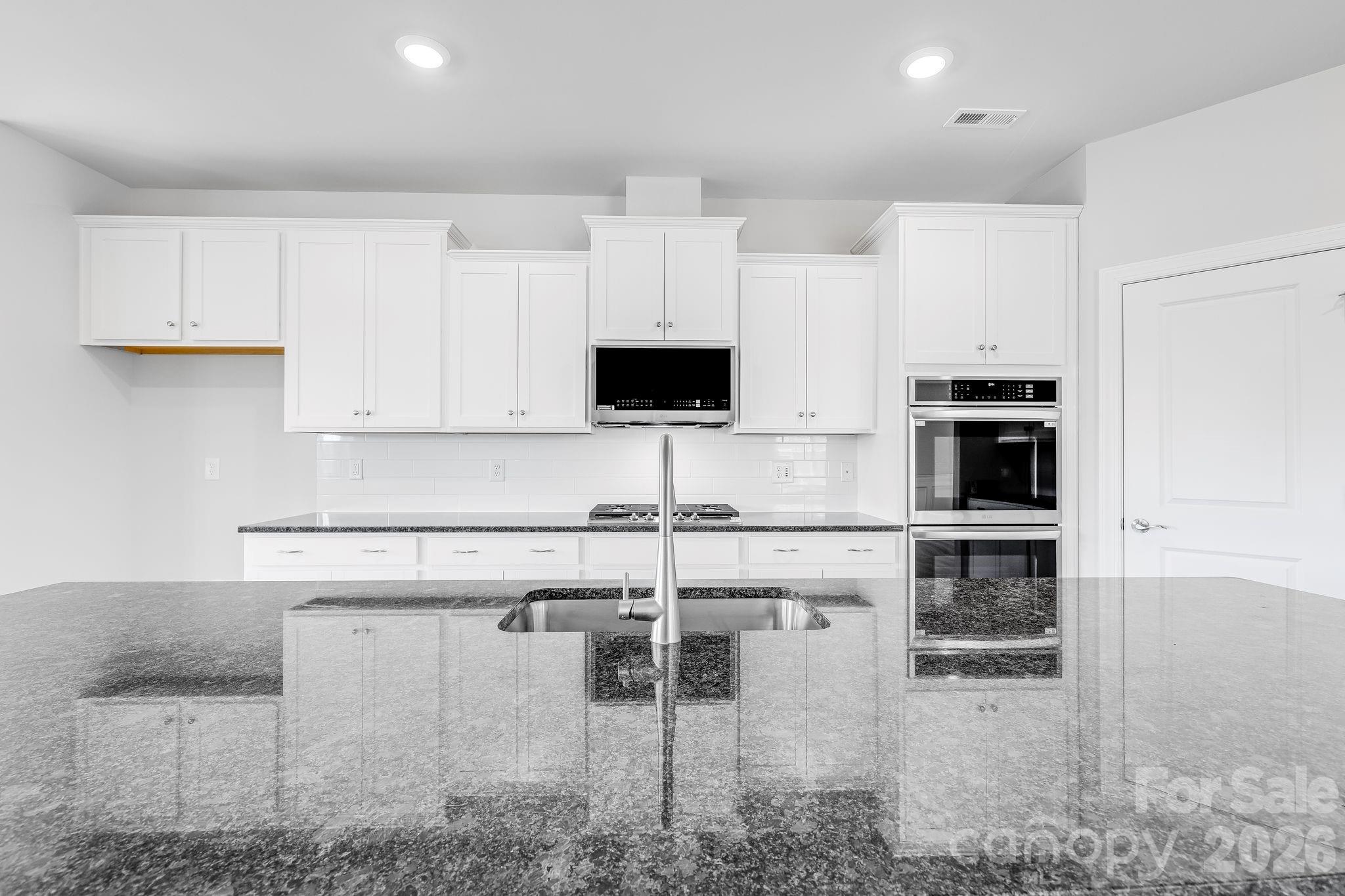 2287 Moon Crst Road, Unit 143 Lancaster, SC 29720 - Photo 19 of 35 a kitchen with stainless steel appliances kitchen island granite countertop a stove and a sink