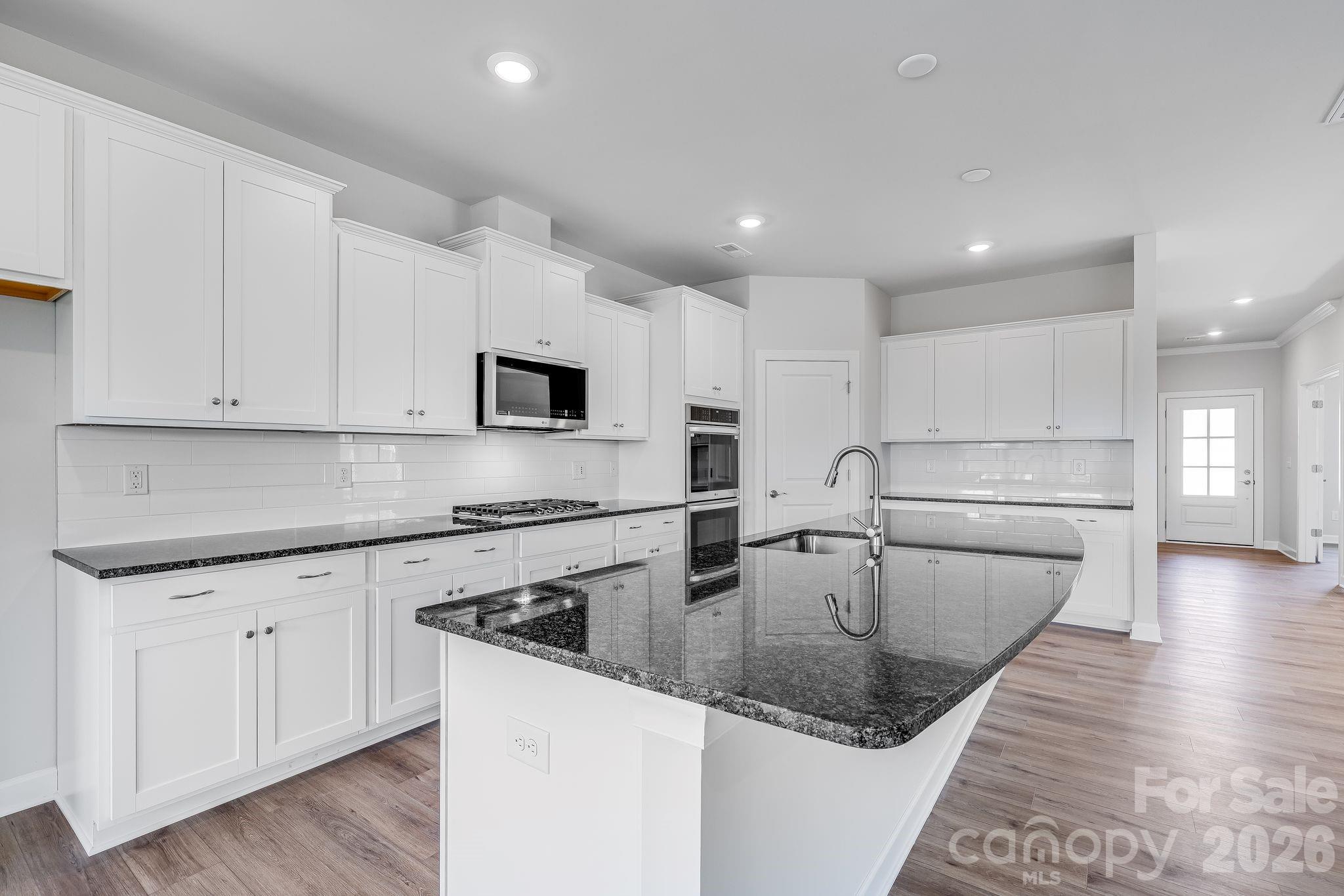 2287 Moon Crst Road, Unit 143 Lancaster, SC 29720 - Photo 20 of 35 a kitchen with stainless steel appliances granite countertop a sink a stove and a wooden floors