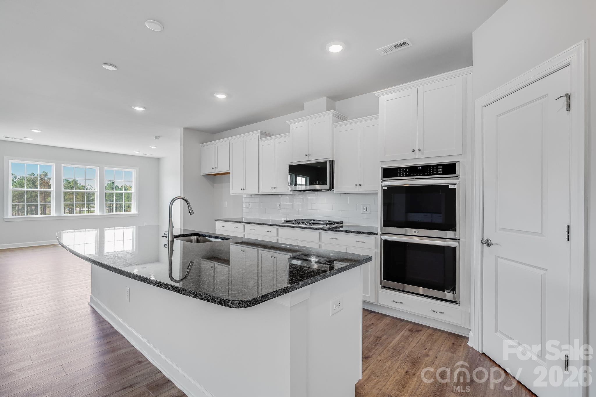 2287 Moon Crst Road, Unit 143 Lancaster, SC 29720 - Photo 21 of 35 a kitchen with stainless steel appliances granite countertop a sink a stove a microwave and a refrigerator