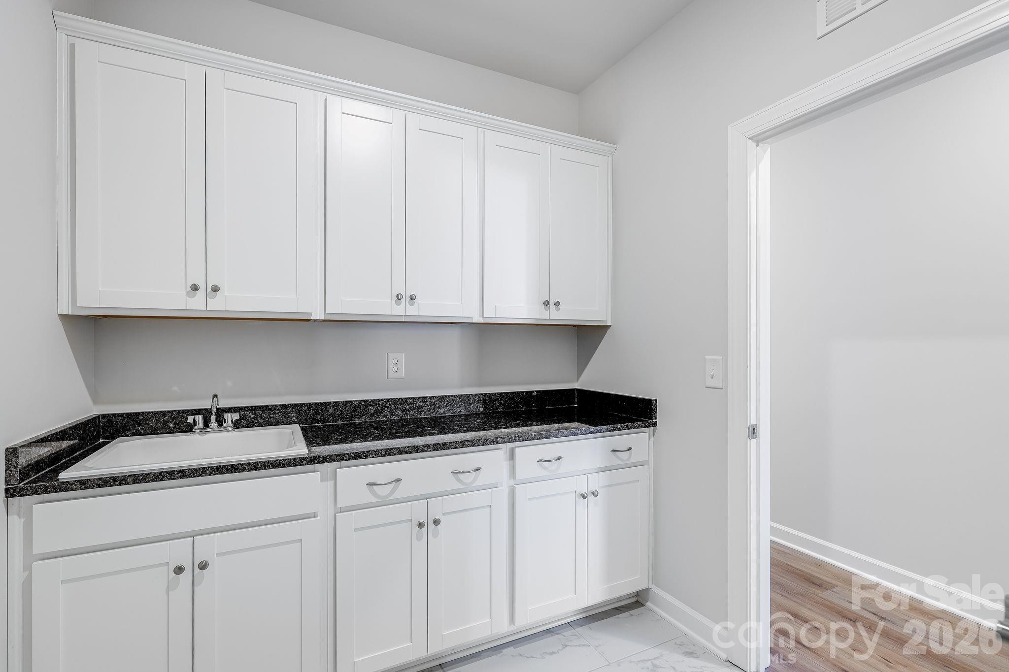 2287 Moon Crst Road, Unit 143 Lancaster, SC 29720 - Photo 33 of 35 a kitchen with granite countertop white cabinets and a sink