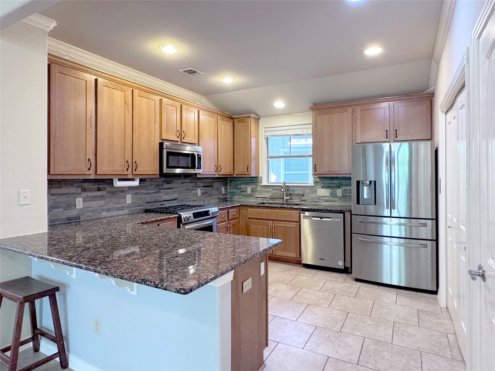 9707 Anderson Mill Road, Unit 21 Austin, TX 78750 - Photo 12 of 27 Polished granite countertops and classic wood cabinetry define this functional kitchen space.