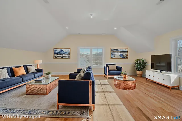 a living room with furniture a flat screen tv and a large window