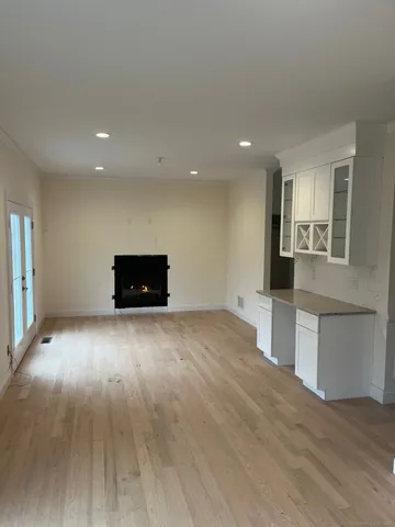 a view of empty room with wooden floor and window
