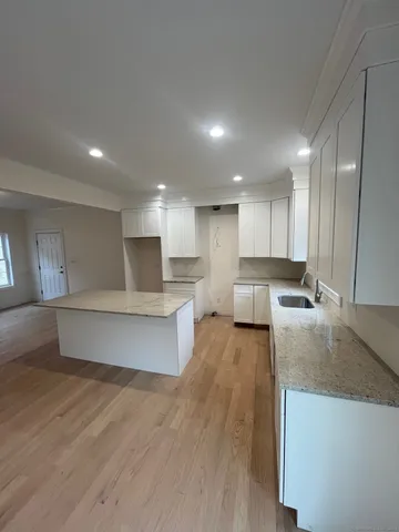 a large kitchen with kitchen island a stove a refrigerator a sink and a counter top space