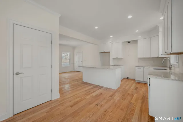 a kitchen with wooden floors and white cabinets