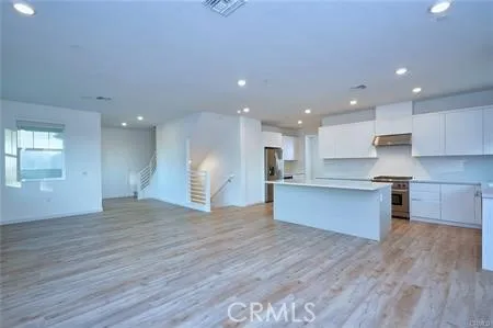 a large kitchen with stainless steel appliances granite countertop a large counter top a sink and a stove