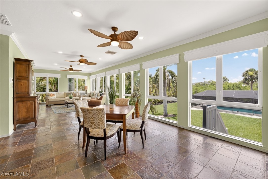 6120 Henderson Road Sanibel, FL 33957 - Photo 17 of 50 a dining room with furniture a chandelier and a rug