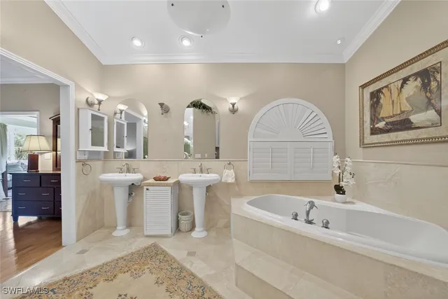 a bathroom with a tub a double vanity sink and a mirror
