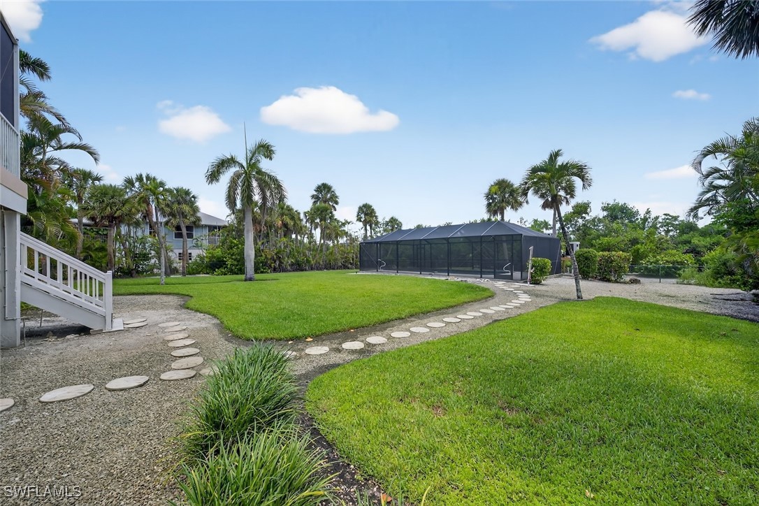 6120 Henderson Road Sanibel, FL 33957 - Photo 38 of 50 a view of a house with a swimming pool and a yard