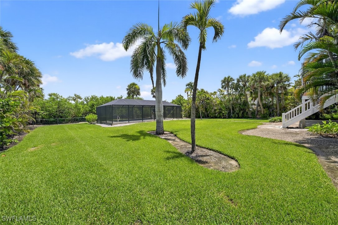 6120 Henderson Road Sanibel, FL 33957 - Photo 39 of 50 a view of a house with a yard and palm trees