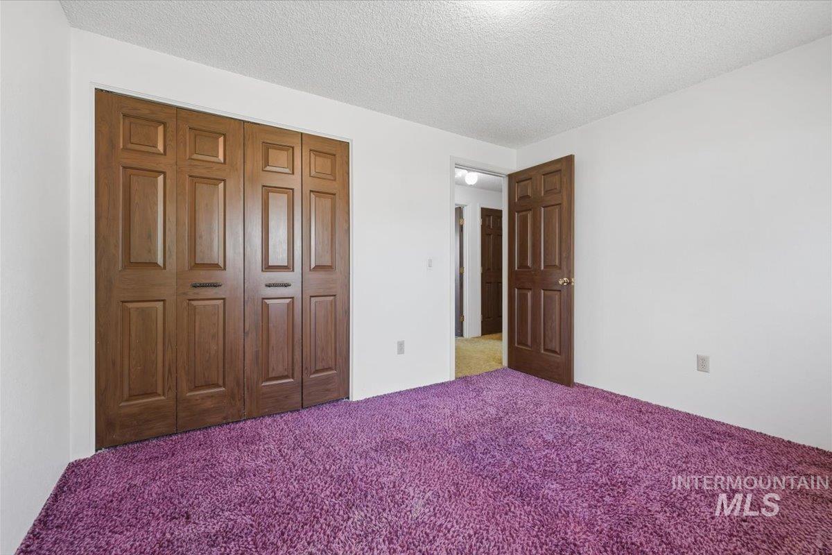 1311 North Middleton Road Nampa, ID 83651 - Photo 30 of 49 Room featuring plush purple carpeting, white walls, and a textured white ceiling