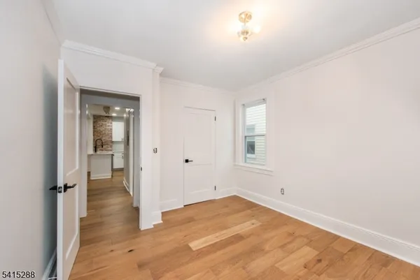a view of a room with wooden floor and a window