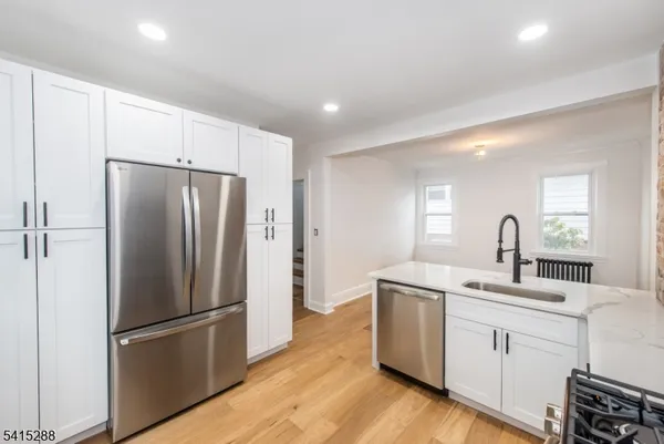 a kitchen with a refrigerator sink and white cabinets