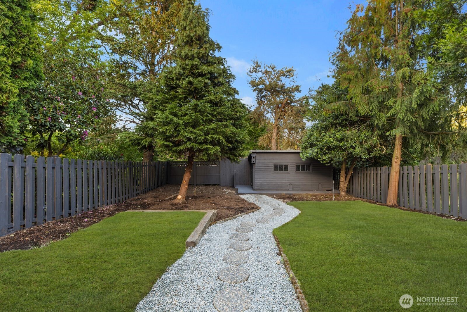 8216 Interlake Avenue North Seattle, WA 98103 - Photo 28 of 36 a view of a backyard with table and chairs and a large tree