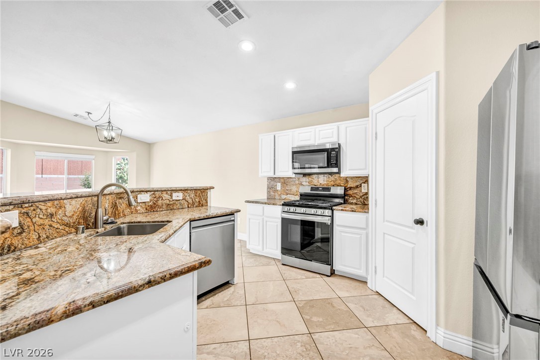 6405 North Raptor Court North Las Vegas, NV 89084 - Photo 24 of 66 Granite counters and stainless steel appliances complete this well-appointed kitchen.