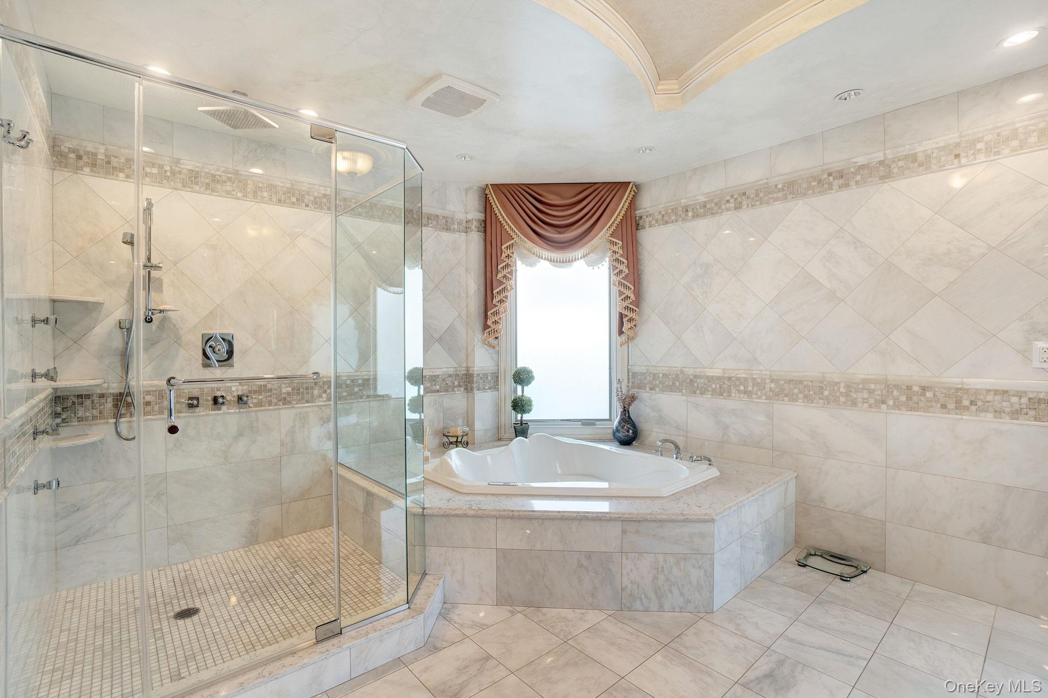 181-30 Tudor Road Queens, NY 11432 - Photo 27 of 46 Full bathroom featuring a shower stall, tile walls, a garden tub, tile patterned flooring, and crown molding