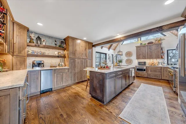 a view of a hallway with furniture and wooden floor