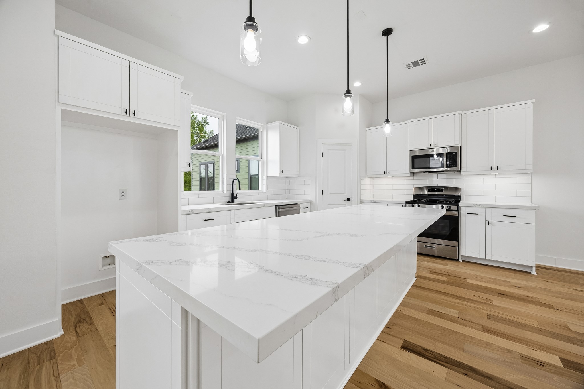 424 Sikes Street Houston, TX 77018 - Photo 3 of 12 a kitchen with kitchen island a stove a sink a center island and cabinets